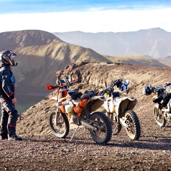 Billy standing next to four motorbikes during a bike adventure to Iceland